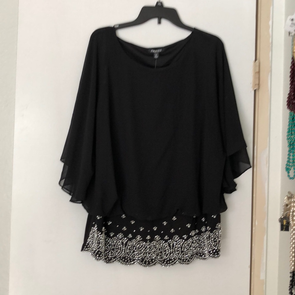 Black top with sequins at the hem of the blouse